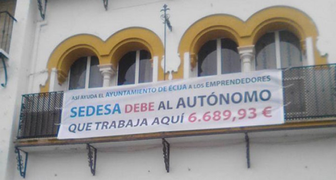 Se decreta incoación contra un empresario de Écija por manifestar en una pancarta un débito del Ayuntamiento.